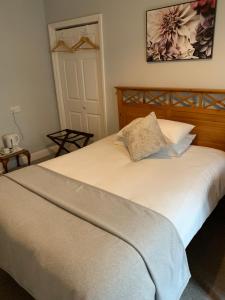 a bedroom with a white bed with a wooden headboard at Beachy Rise in Eastbourne