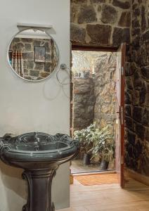 a stone bathroom with a sink and a mirror at Vaga Copper Castle in Vagamon