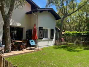 a house with a table and chairs in a yard at Gite du Lac T4 in Vieux-Boucau-les-Bains