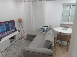 a living room with a couch and a tv at Apartamento Cassoma in Amadora