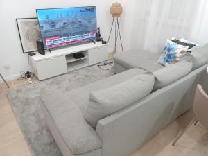 a living room with a couch and a flat screen tv at Apartamento Cassoma in Amadora