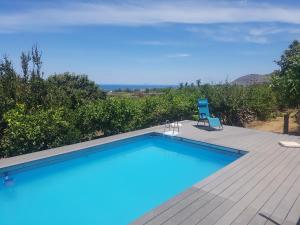 a blue swimming pool with a blue chair and a deck at Holiday Homes in Campofelice di Roccella