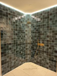 a bathroom with a blue tiled shower with a hose at La Única in Coín +42 photos