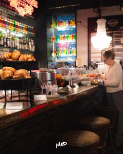 Eine Frau steht mit Essen an einem Tresen in einem Restaurant. in der Unterkunft ibis Styles Lausanne Center MadHouse in Lausanne + 95 Fotos