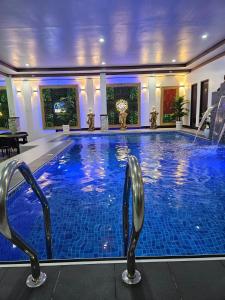 a large swimming pool with two chairs in a building at Private Resort in Batangas in Lian