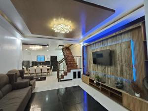 a living room with a tv and a couch and a table at Private Resort in Batangas in Lian