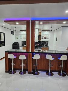 a kitchen with a bar with stools at Private Resort in Batangas in Lian