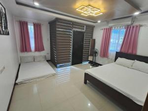 a bedroom with two beds and red curtains at Private Resort in Batangas in Lian +17 photos
