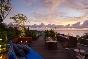 a patio with a table and chairs and the ocean at Desa Potato Head Bali in Seminyak