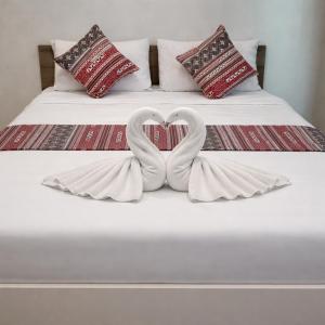 two white swans forming a heart on a bed at River Bend villas 1 in Mae Rim