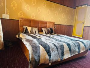 a bed with a wooden headboard in a room at Delight Homestay Gulmarg in Gulmarg