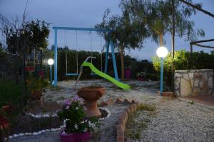 a playground with a green slide in a backyard at Holiday Homes in Campofelice di Roccella