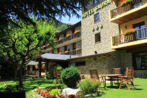 a hotel with a table and chairs in a yard at Hotel Saurat in Espot