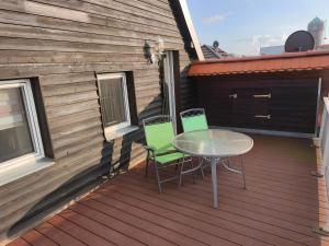 a patio with a table and chairs on a deck at Maisonette with large terrace in Leipzig