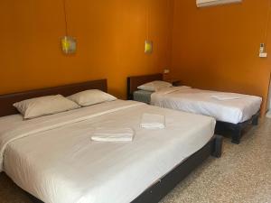 two beds in a room with orange walls at Panngernpanthong inn resort in Ban Nong Chaeng +7 photos