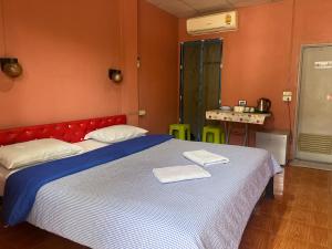 a bedroom with a large bed with two towels on it at Panngernpanthong inn resort in Ban Nong Chaeng