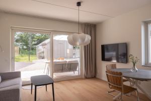 a living room with a table and a dining room at The Oak - Ekerum Öland in Borgholm