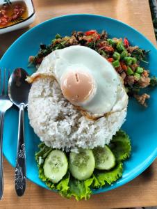 a blue plate with rice and an egg on top at River Bend villas 1 in Mae Rim