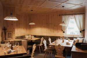 a restaurant with wooden walls and tables and chairs at Residence Ciasa Vedla in Badia