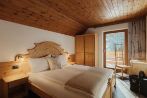 a bedroom with a large bed and a window at Residence Ciasa Vedla in Badia