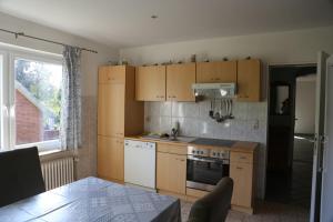 a small kitchen with wooden cabinets and a table at Ferienhaus Kappeln in Rabenkirchen-Faulück