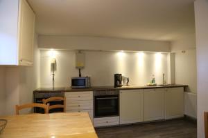 a kitchen with white cabinets and a stove top oven at Ferienhaus Kappeln in Rabenkirchen-Faulück +11 photos