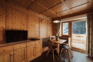 a living room with a table and a television in a cabin at Residence Ciasa Vedla in Badia
