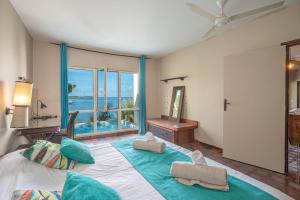 a bedroom with a large bed with a large window at Villa Les Agaves front de mer in Le François +65 photos