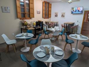 a dining room with tables and chairs with dishes on them at Hostal El Convent de Moncada in Moncada