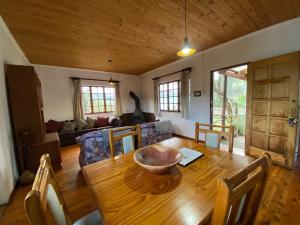 a dining room with a wooden table and a couch at Sani Lodge & Cottages in Sani Pass