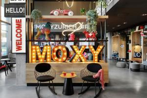 a store with two chairs and a sign that says wow at Moxy Zurich in Zurich