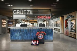a store with luggage sitting in front of a counter at Moxy Zurich in Zurich
