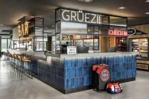 a bar in a restaurant with a drink counter at Moxy Zurich in Zurich