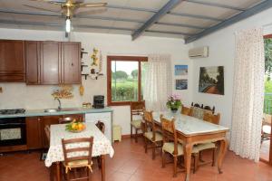 a kitchen and dining room with a table and chairs at Holiday Homes in Campofelice di Roccella