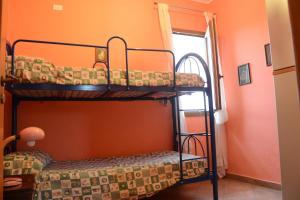 two bunk beds in a room with an orange wall at Holiday Homes in Campofelice di Roccella +39 photos