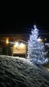 un arbre de Noël blanc devant un bâtiment dans l'établissement Gresil Residence, à Champoluc