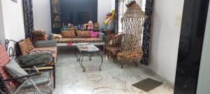 a living room with chairs and a mirror at Raina's Home in Bhuj