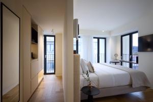 a bedroom with a white bed and some windows at Bellén Athens Ηotel in Athens