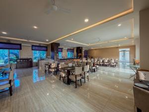 a restaurant with tables and chairs in a room at Spree Resort At Century Wintersun in Dod Ballāpur