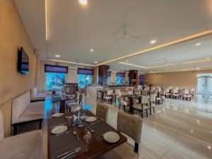 a restaurant with tables and chairs in a room at Spree Resort At Century Wintersun in Dod Ballāpur