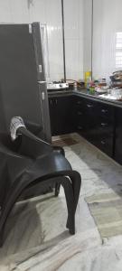 a kitchen with a chair in the middle of a room at Raina's Home in Bhuj