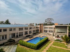 an exterior view of a building with a swimming pool at Spree Resort At Century Wintersun in Dod Ballāpur