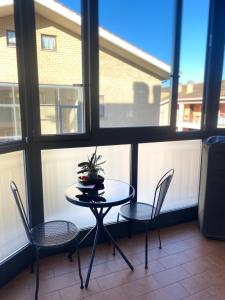 a table and chairs in a room with windows at Granaretto 27 in Palidoro +2 photos