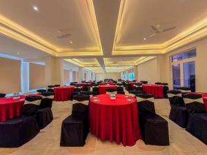 a banquet hall with red tables and black chairs at Spree Resort At Century Wintersun in Dod Ballāpur +88 photos