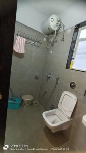 a bathroom with a toilet and a shower with a camera at Sylevo 2bhk Baner in Pune +4 photos