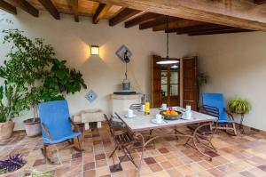 a dining room with a table and blue chairs at Sort Nova in Montuiri