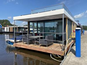 a house boat parked on the water at Houseboat Robbedoes in Offingawier