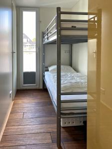 a bunk bed in a room with wooden floors at Houseboat Robbedoes in Offingawier +3 photos