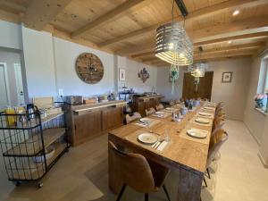 a large dining room with a long table and a kitchen at HOSTEL B&B Mama Mia - Budgetverblijf in Zaton Obrovački