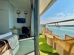 a room with a balcony with a bed and chairs at Mulberry Homes Supernova in Noida